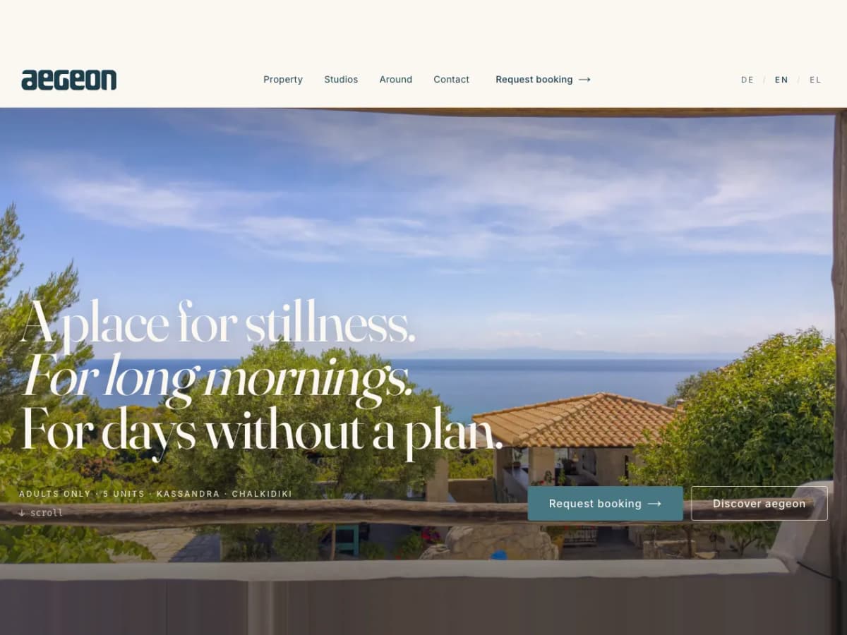 Aegeon: English home page hero, the headline A place for stillness over a terrace sea view in Chalkidiki, with a Request booking button